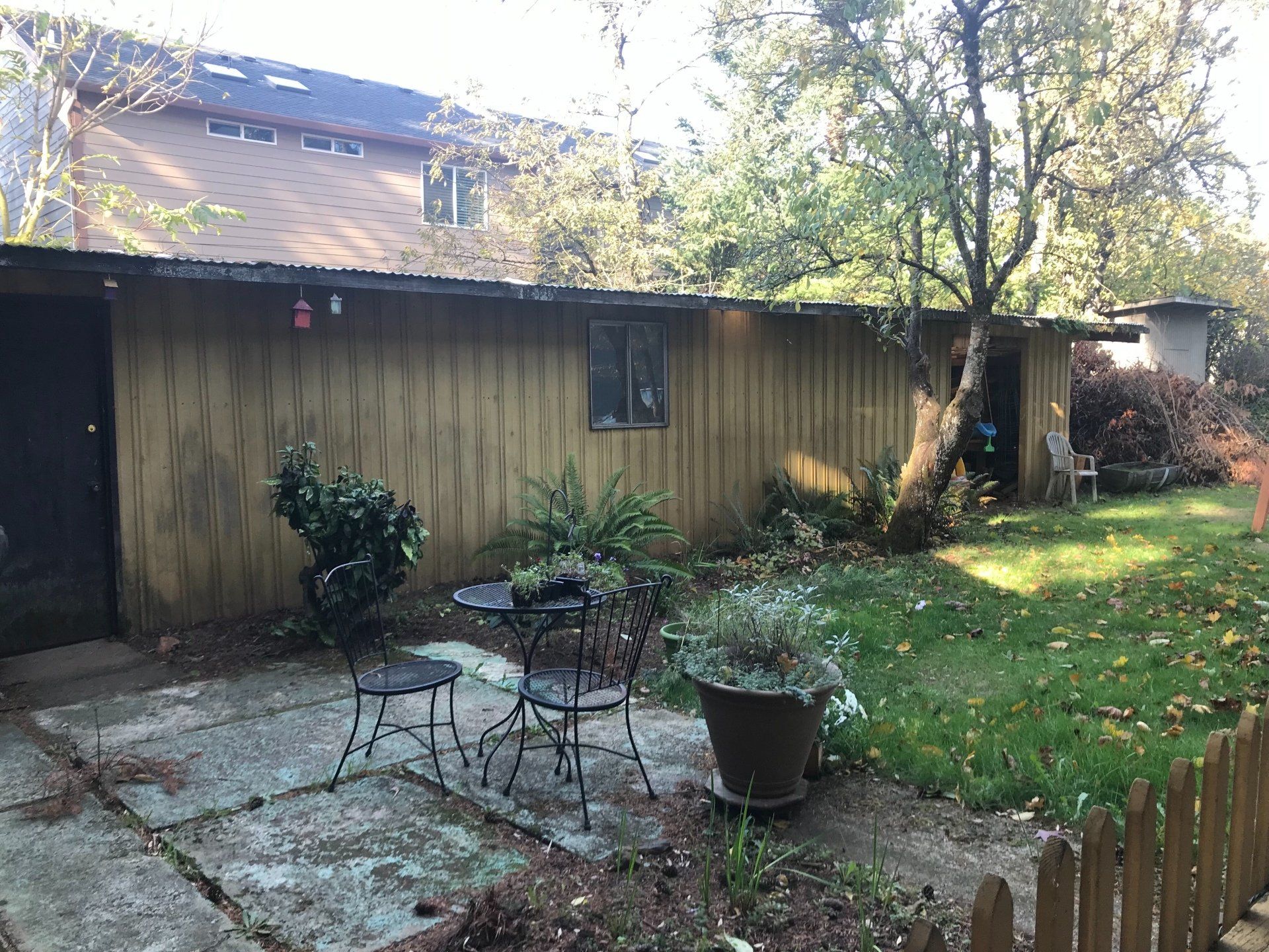 A backyard with a table and chairs in front of a house.