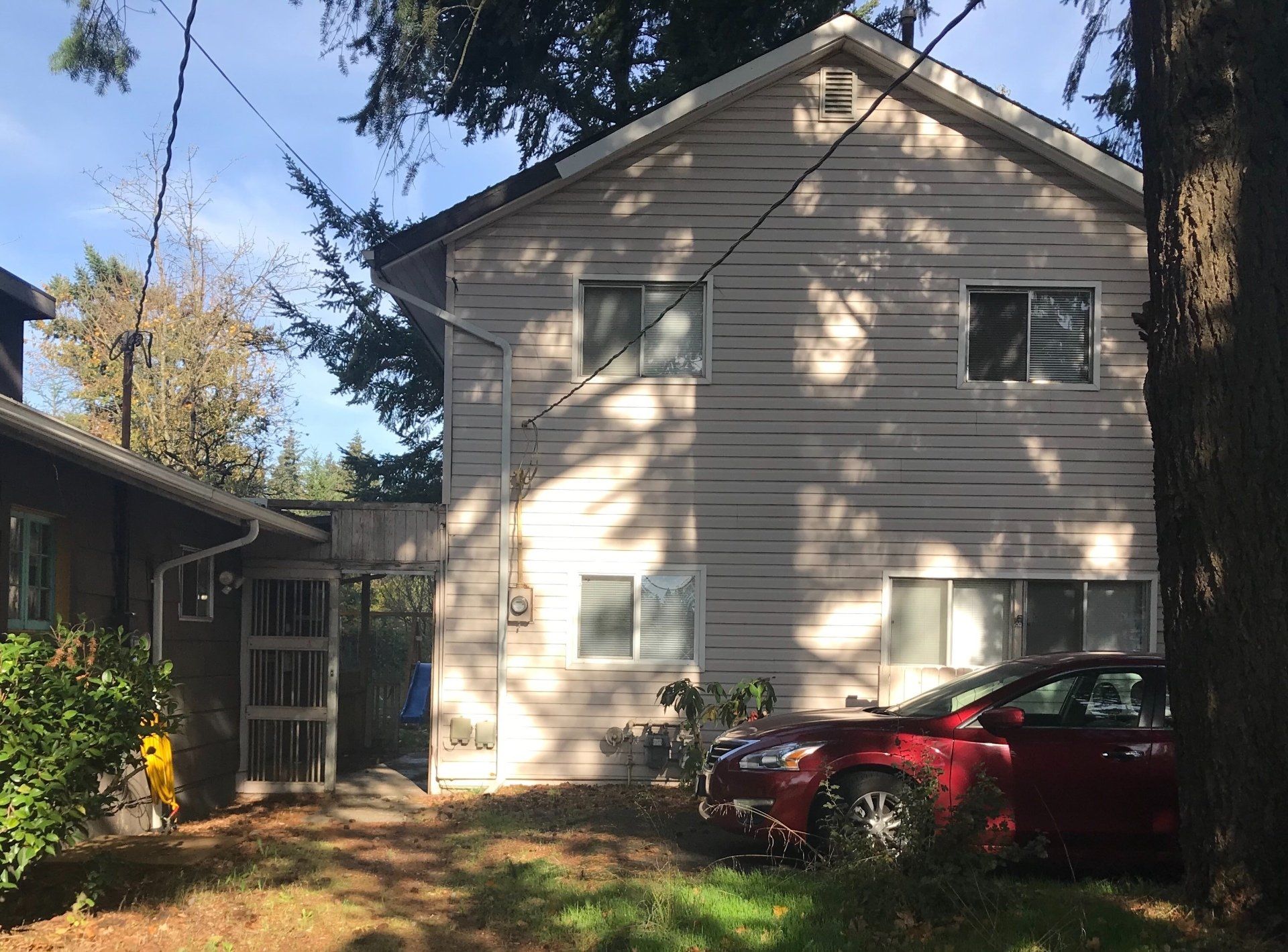 A red car is parked in front of a house.