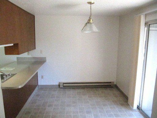 An empty kitchen with a light hanging from the ceiling