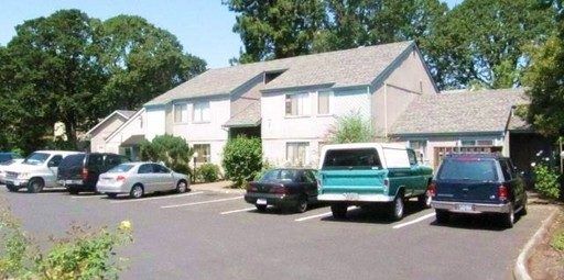 A row of cars are parked in front of a house
