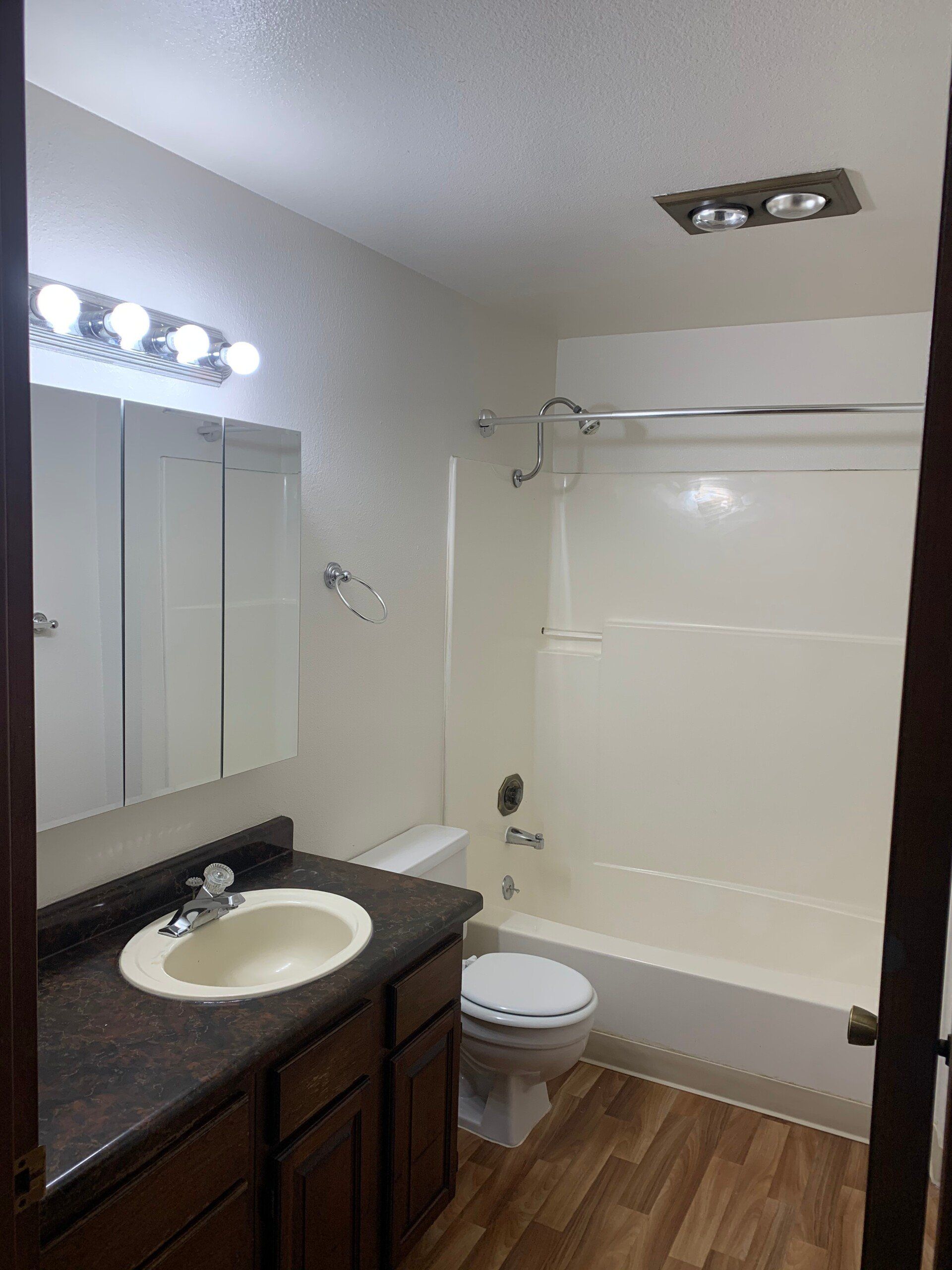 A bathroom with a sink , toilet , tub and mirror.