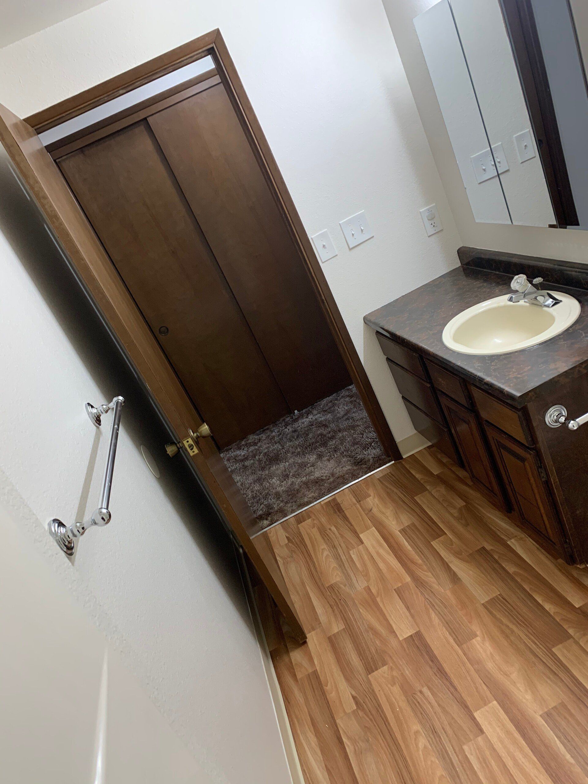 A bathroom with a sink , cabinets , and a door.