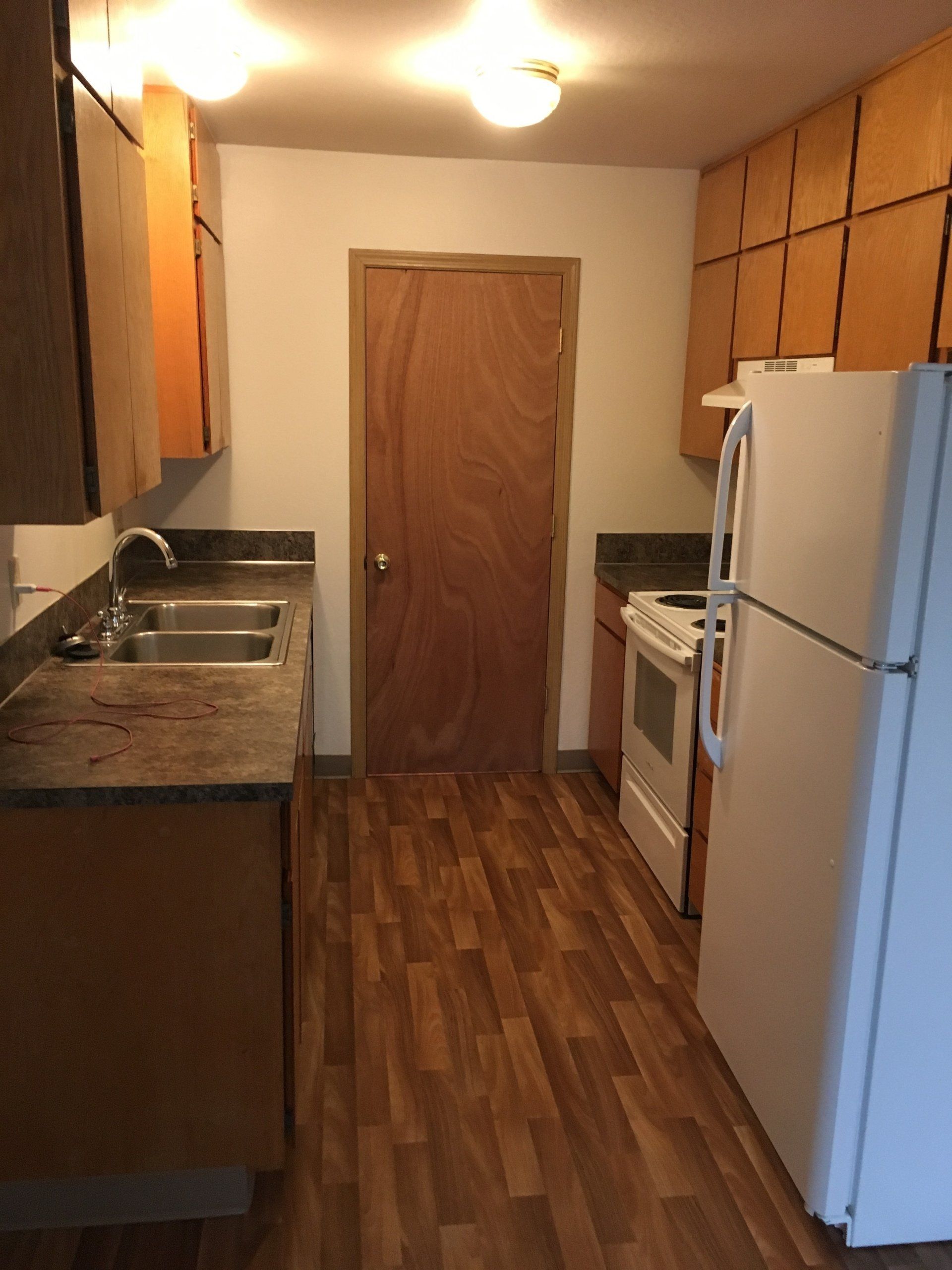 A kitchen with a refrigerator stove and sink