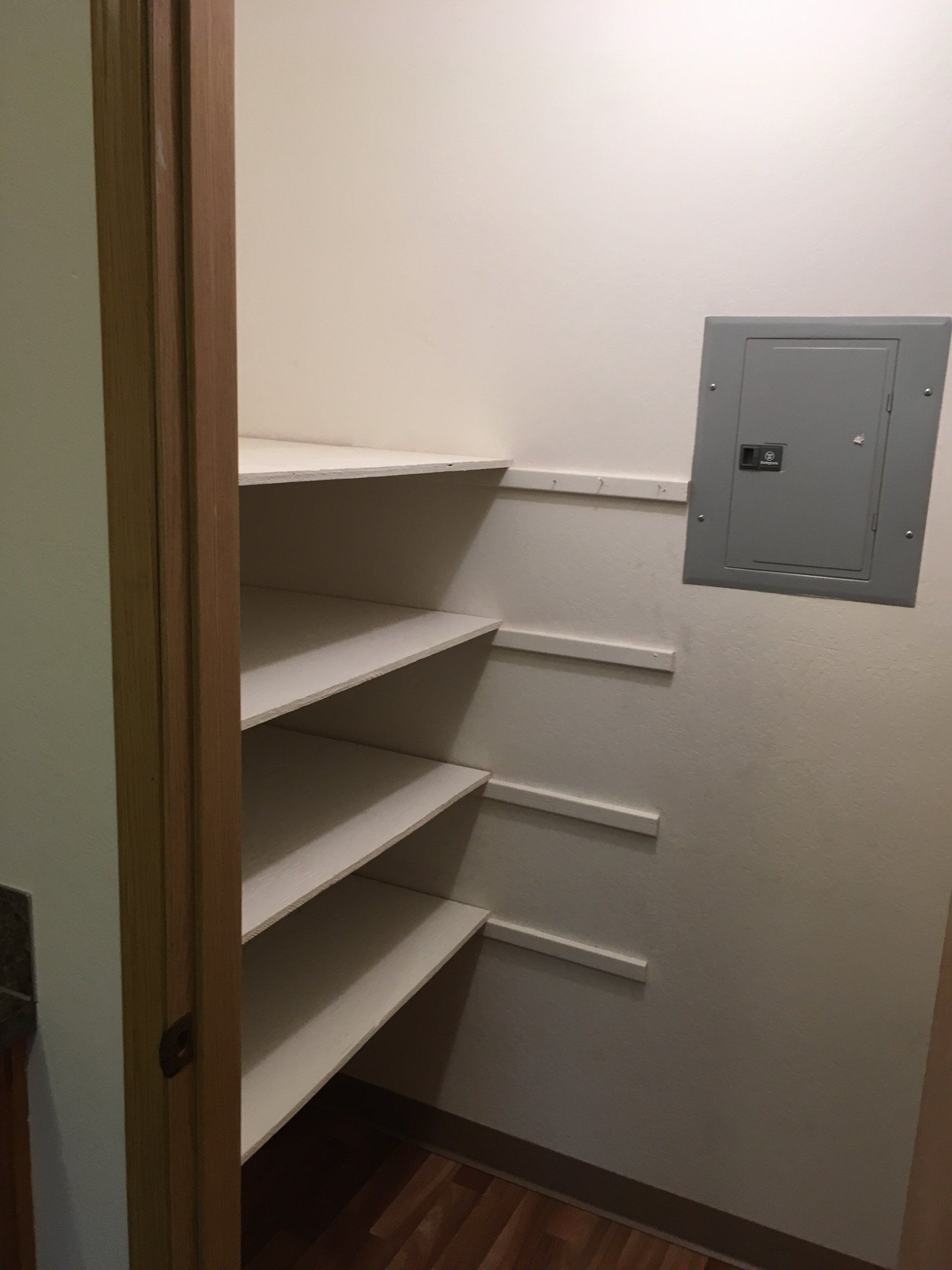 A closet with shelves and a box on the wall