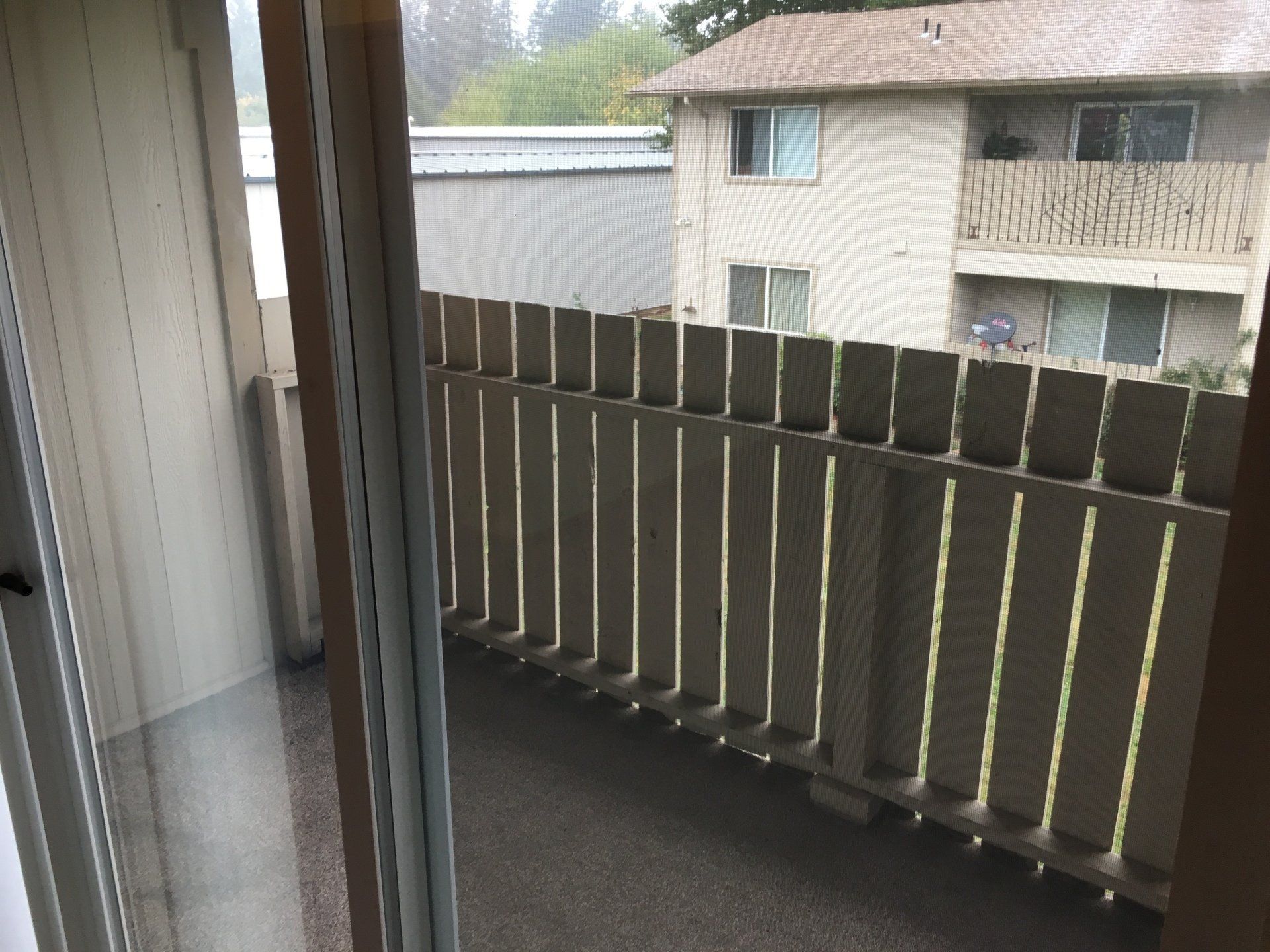 A balcony with a fence and a sliding glass door