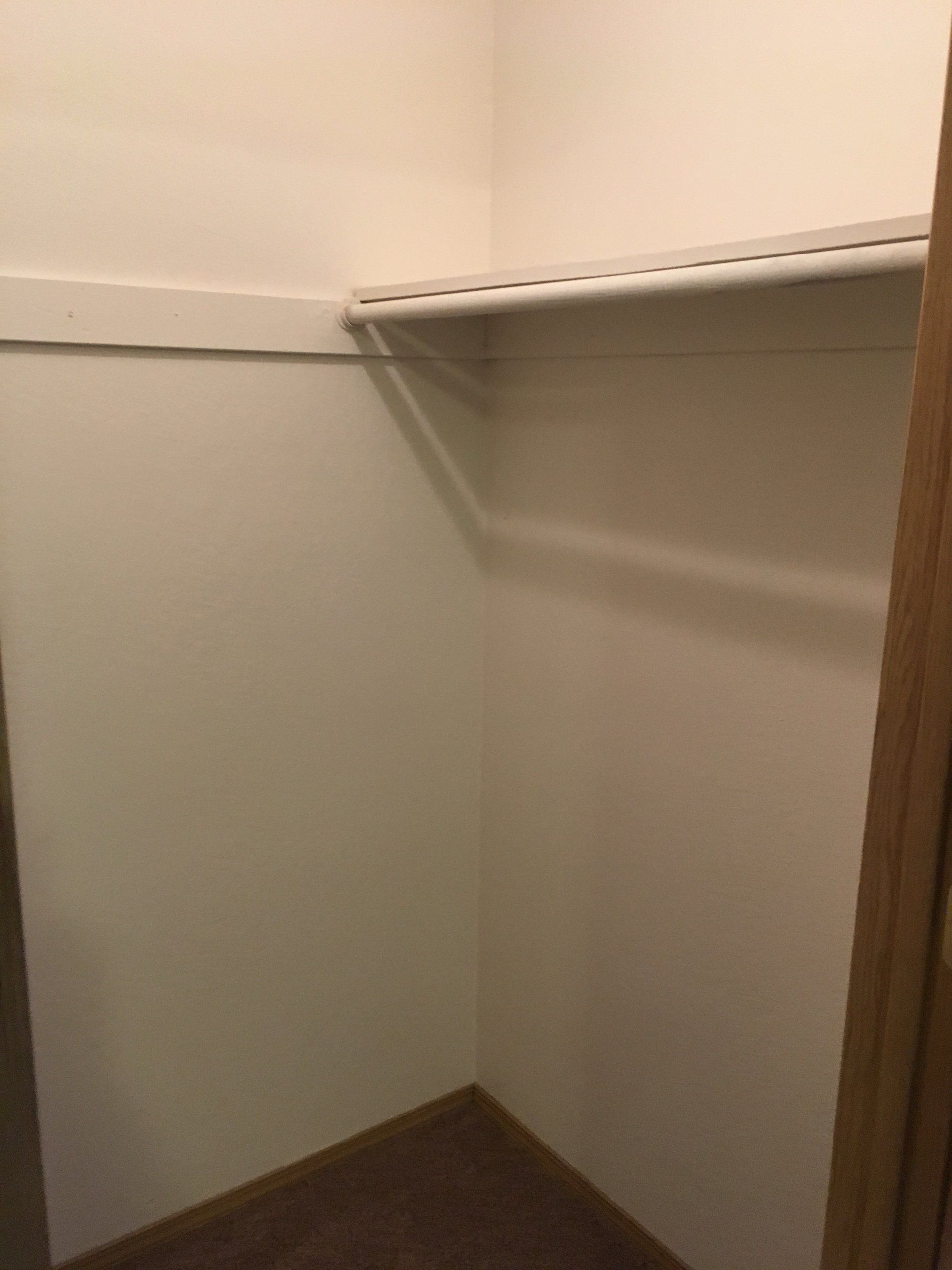 There is a shelf in the corner of the closet.
