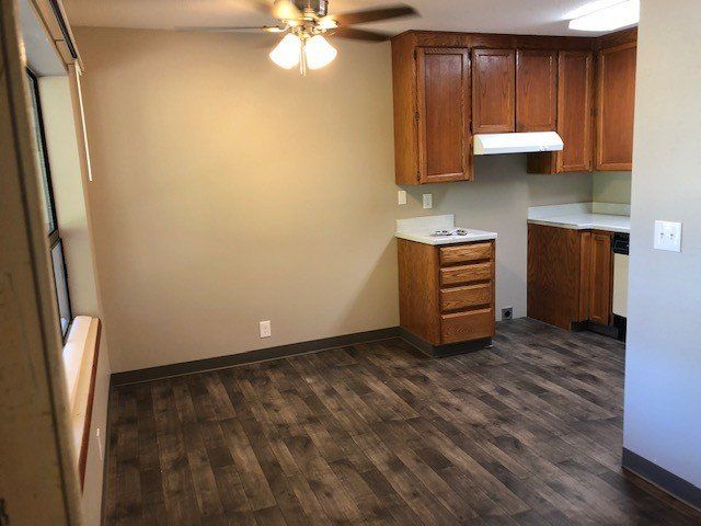 A kitchen with wooden cabinets and a ceiling fan