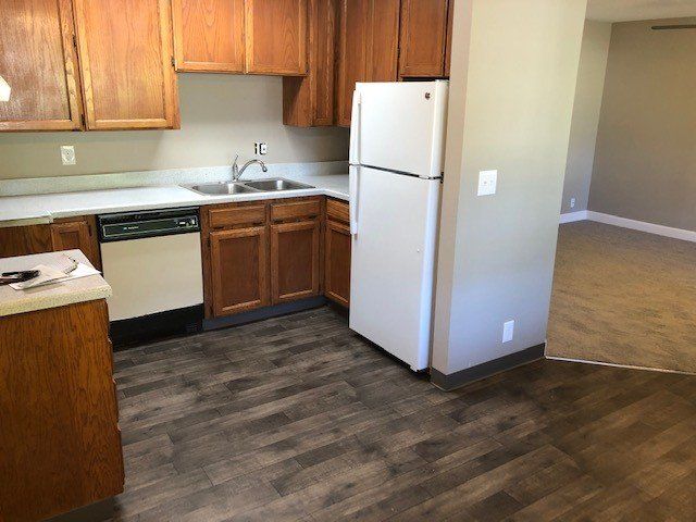 A kitchen with wooden cabinets and a white refrigerator