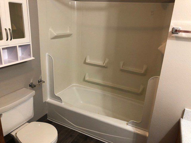 A bathroom with a toilet , bathtub and shower stall.