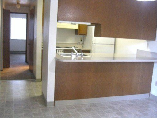 A kitchen with brown cabinets and a white refrigerator
