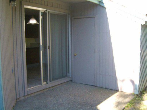 A patio with sliding glass doors and a door