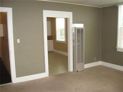 An empty room with a fan in the middle of it