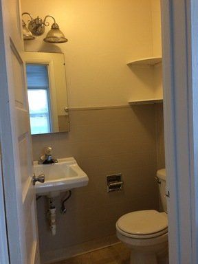 A bathroom with a sink , toilet and mirror.