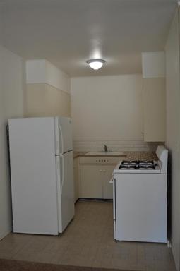 A kitchen with a refrigerator , stove and sink.