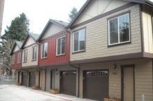 A row of houses with garages and windows on a street.