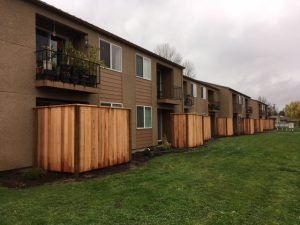 A row of apartment buildings with wooden fences in front of them.