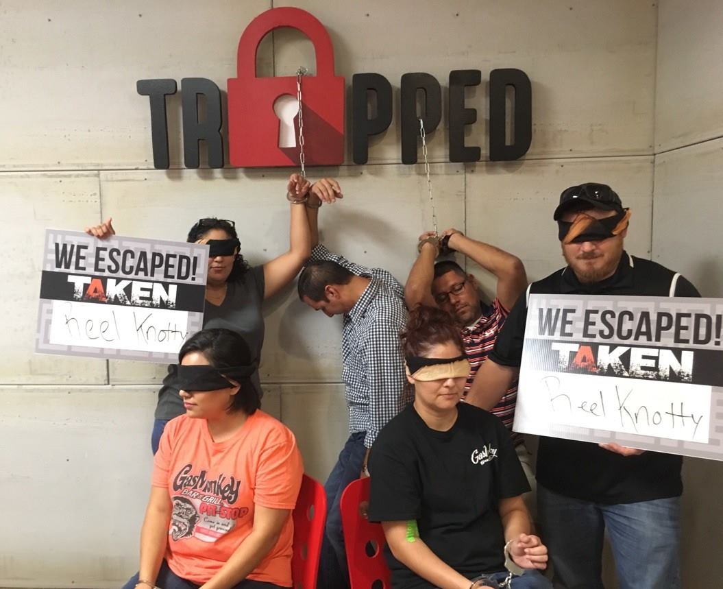 A group of people holding signs that say we escaped taken