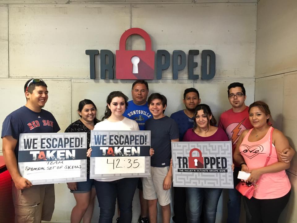 A group of people are standing in front of a sign that says trapped.