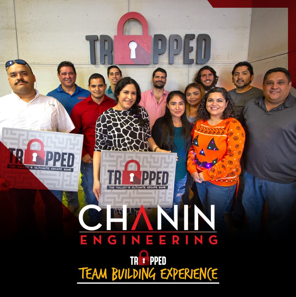 A group of people standing in front of a trapped chainin engineering sign