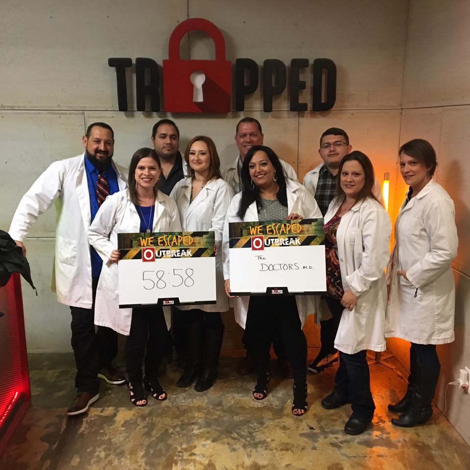 A group of people standing in front of a sign that says trapped