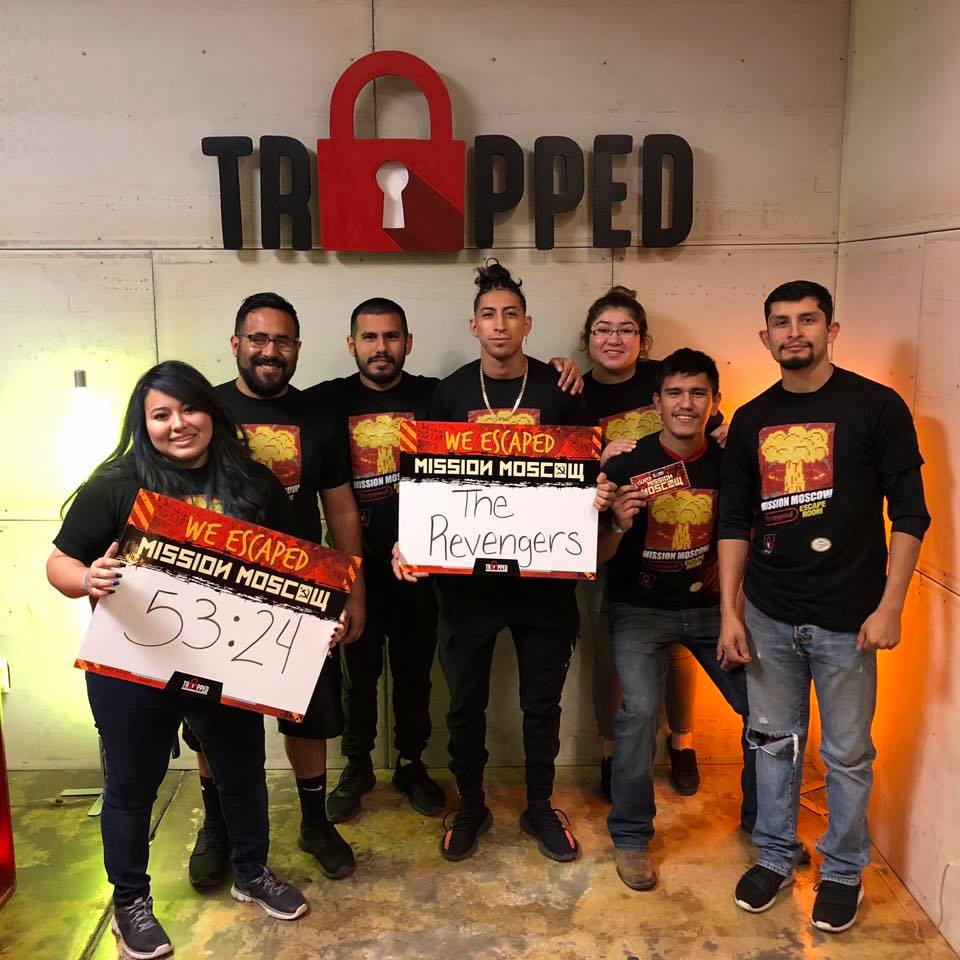 A group of people standing in front of a sign that says trapped