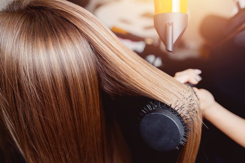 Hairdresser Dries Her Hair — Hair Salon in Townsville, QLD