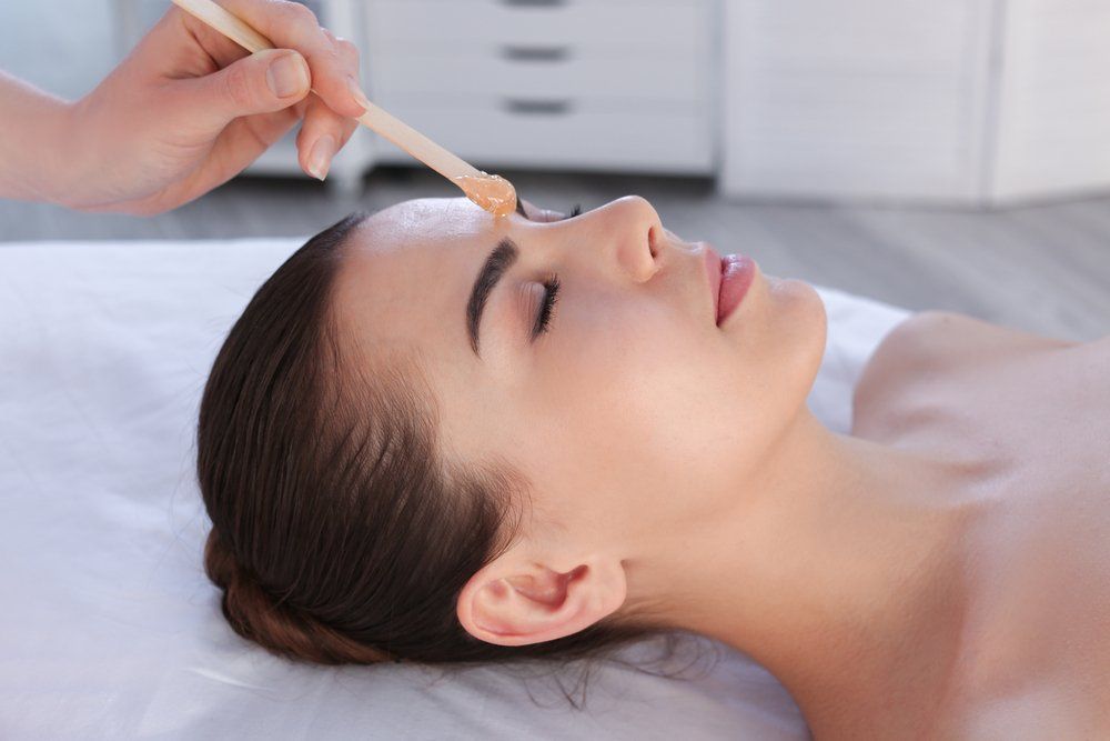 Beautician Applying Facial Wax to Woman's Face — Hair Salon in Townsville, QLD