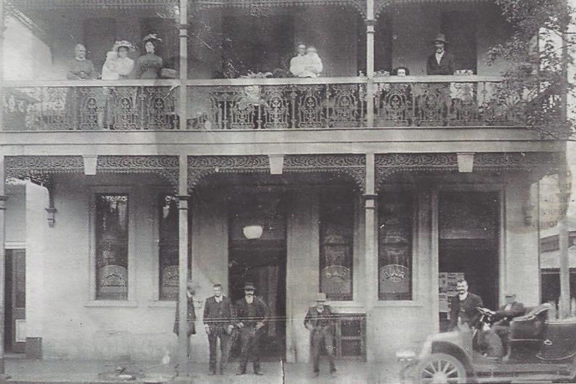 A black and white photo of people standing in front of a building