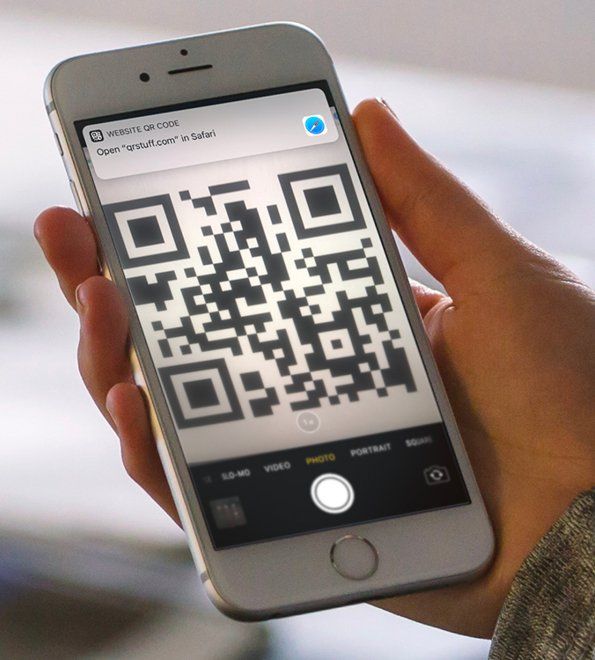 A person is holding a cell phone with a qr code on it