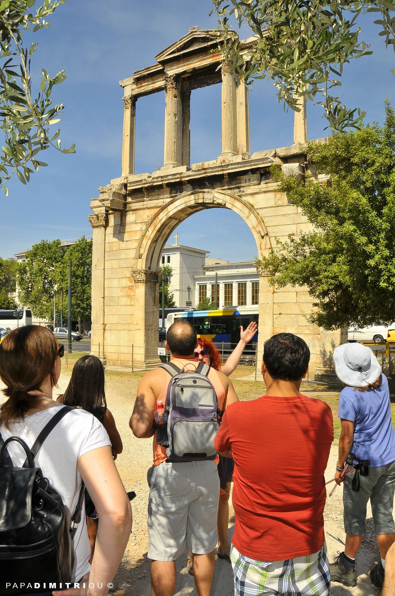 A guide leading a group of tourists at Hadrian's Arch in Athens.