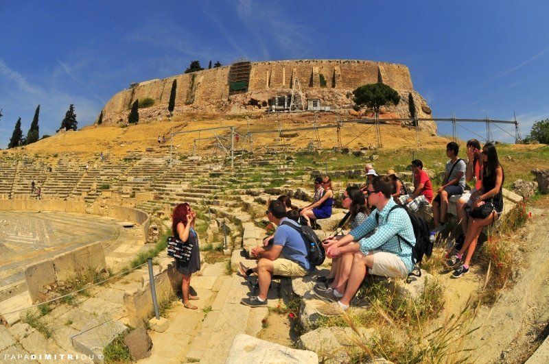 A guide leading a group of tourists at the Acropolis in Athens.