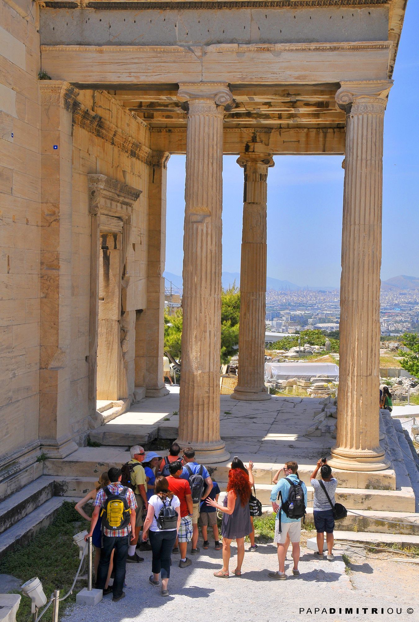 A guide leading a group of tourists at the Acropolis in Athens.