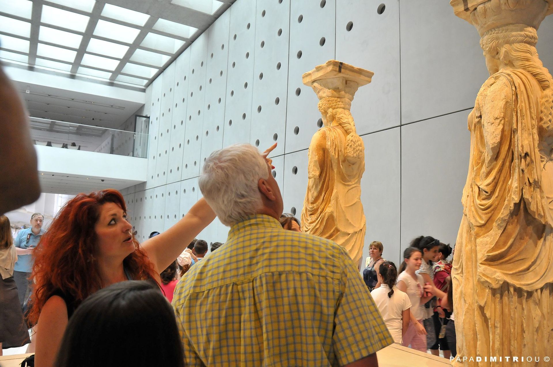 A guide leading a group of tourists at the Acropolis Museum in Athens.