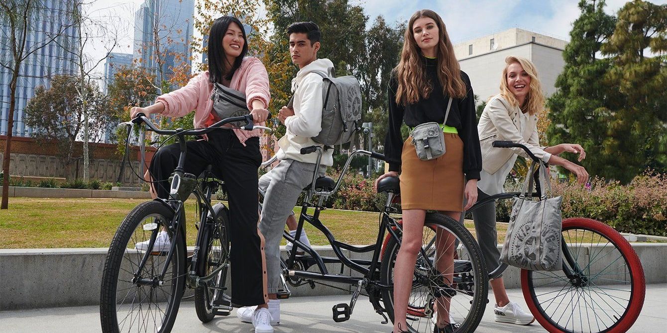 Quattro amici con le biciclette posano all’aperto in un parco in una giornata di sole