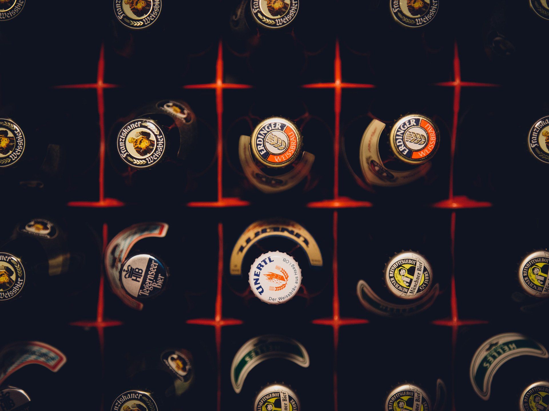 A bunch of beer bottles are lined up in a row