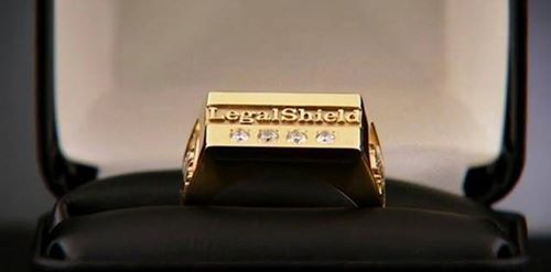 Gold-plated trophy or award plaque with engraved text inside an open black case