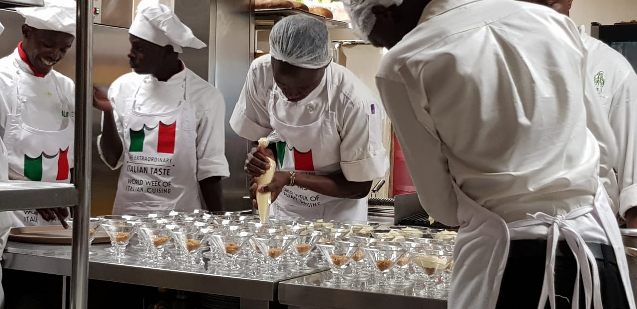 A group of chefs are preparing food in a kitchen.