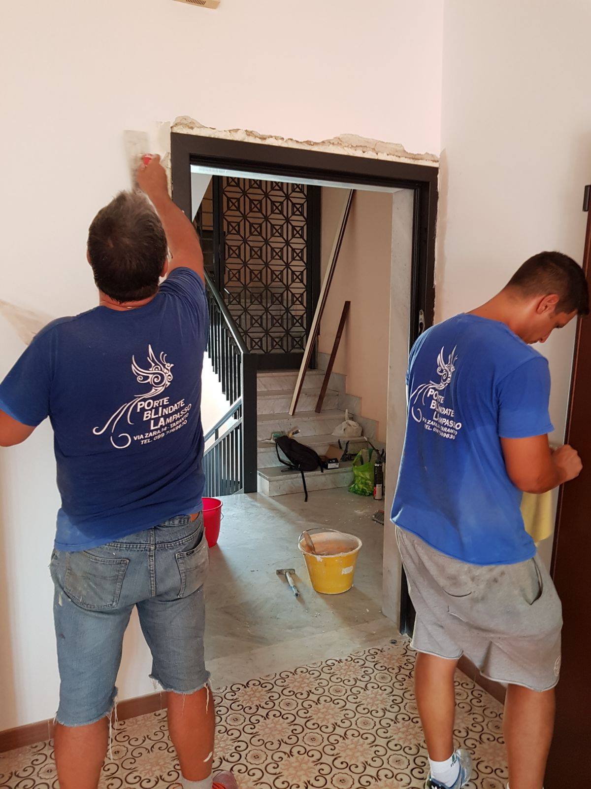 due tecnici installano portone blindato