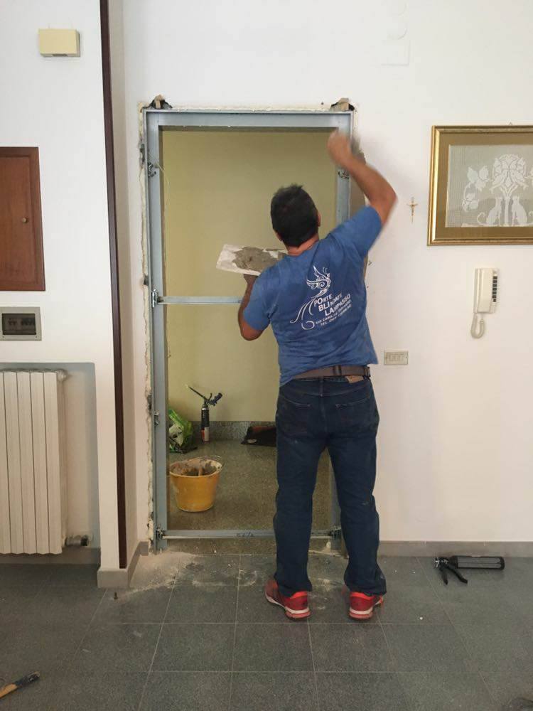 tecnico installa un portone blindato