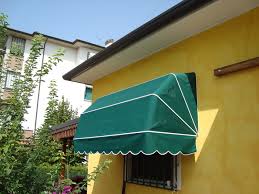 muro giallo acceso con tenda da sole verde