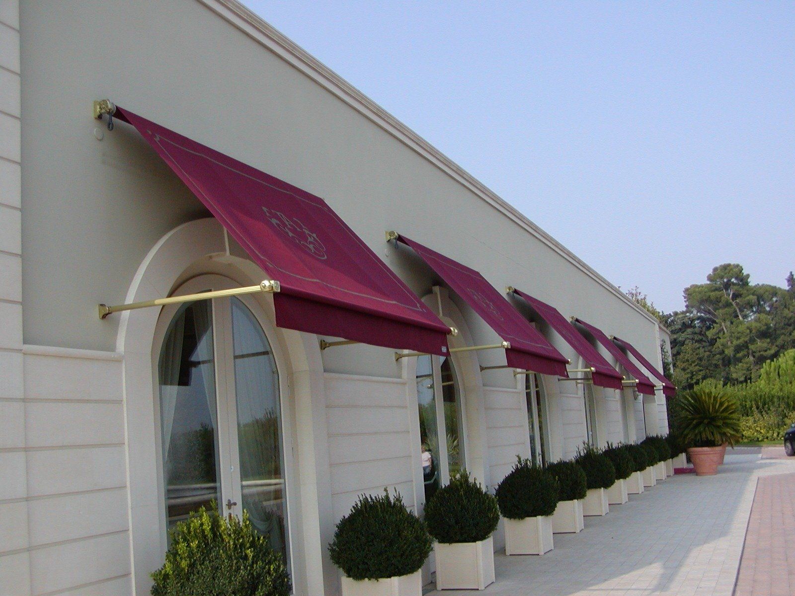 negozio con muro bianco e tende da sole bordeaux