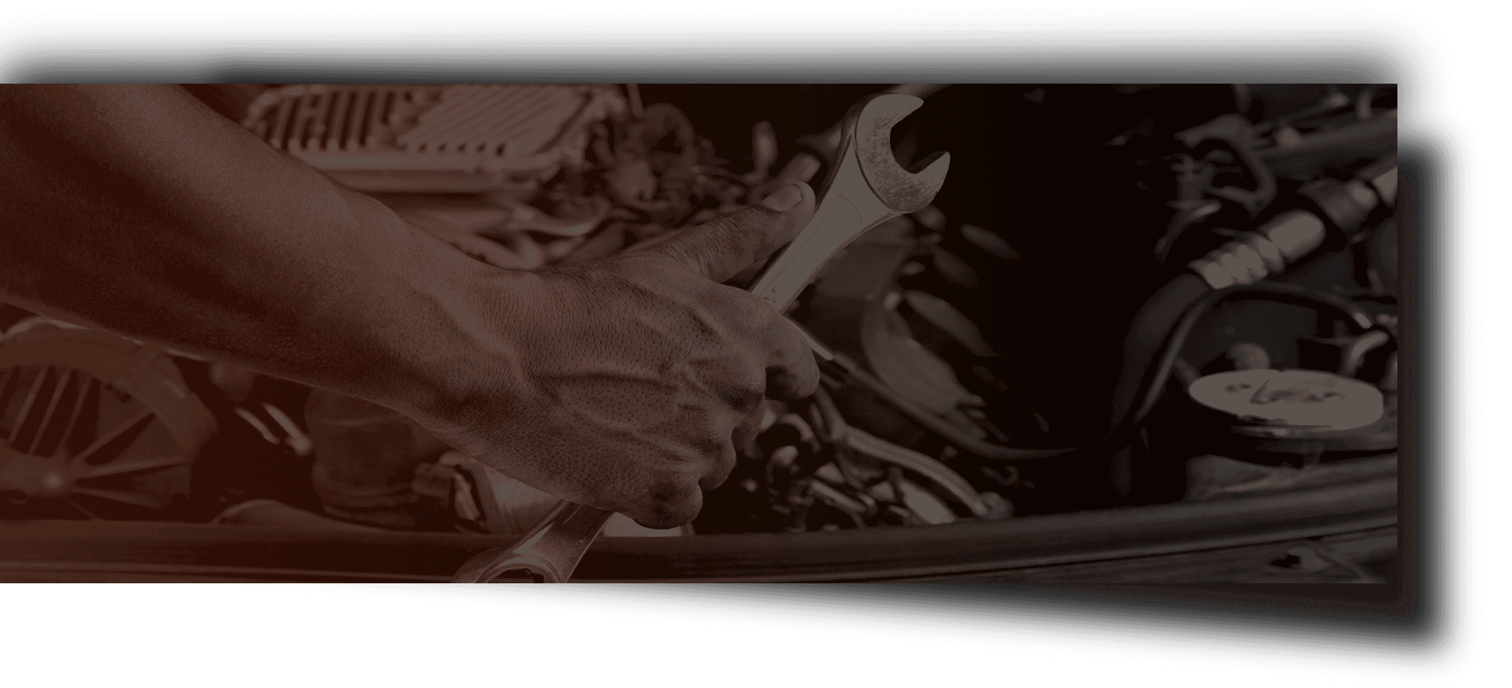 A person is working on a car engine with a wrench.