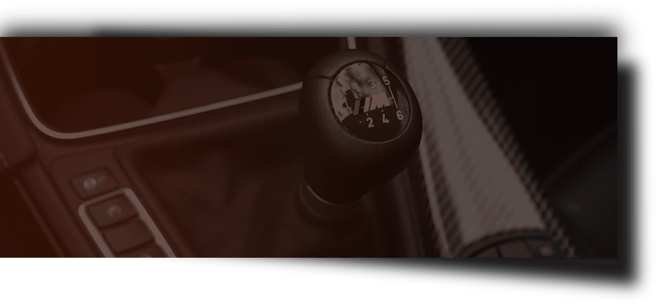 A close up of a car shifter in a dark room.