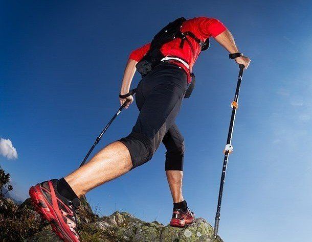 Athletic walker on ridge top, representing the benefit of massage services.