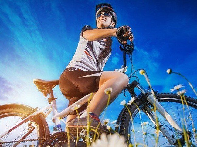 Woman on mountain bike, representing the benefit of massage services.