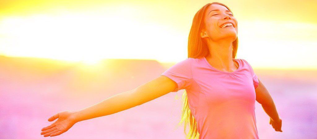 Woman basking in the sun, representing the myriad benefits of radiant heat therapy in our infrared sauna.