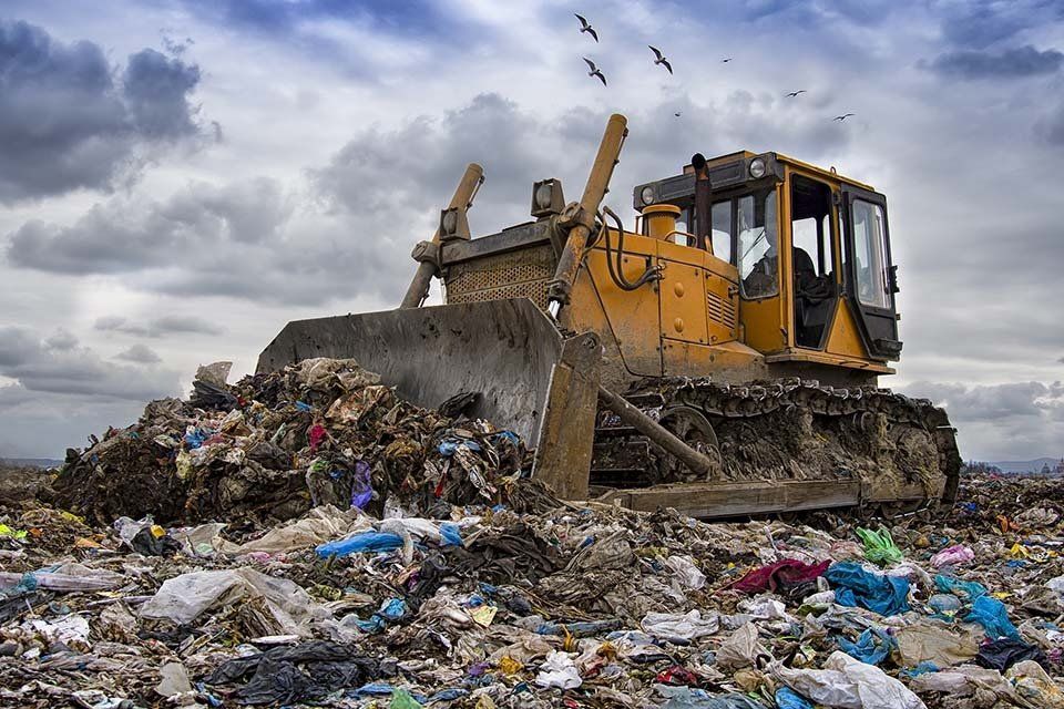 pala meccanica in discarica durante la movimentazione dei rifiuti