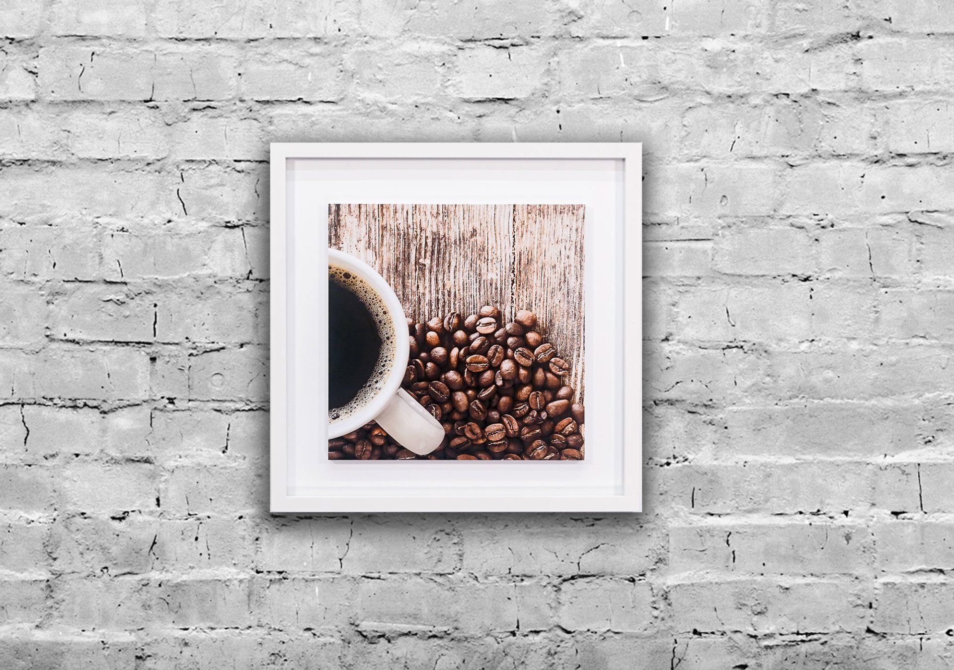 An einer Ziegelwand hängt ein Bild einer Tasse Kaffee und Kaffeebohnen.