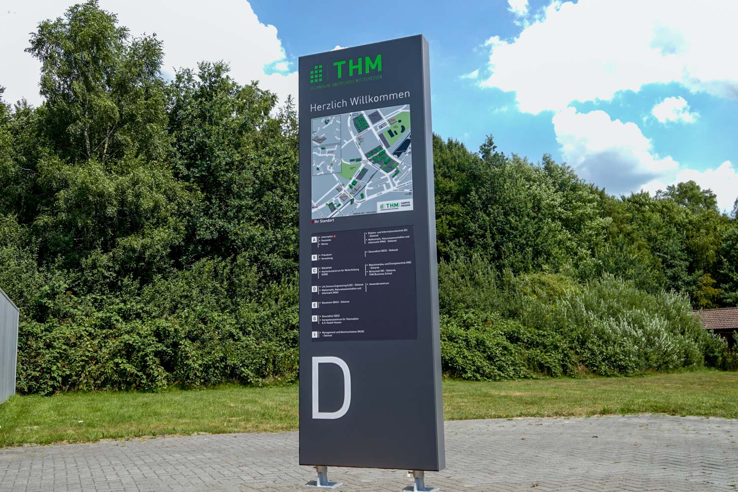 Ein großes Schild mit dem Buchstaben „d“ steht mitten auf einem Feld.