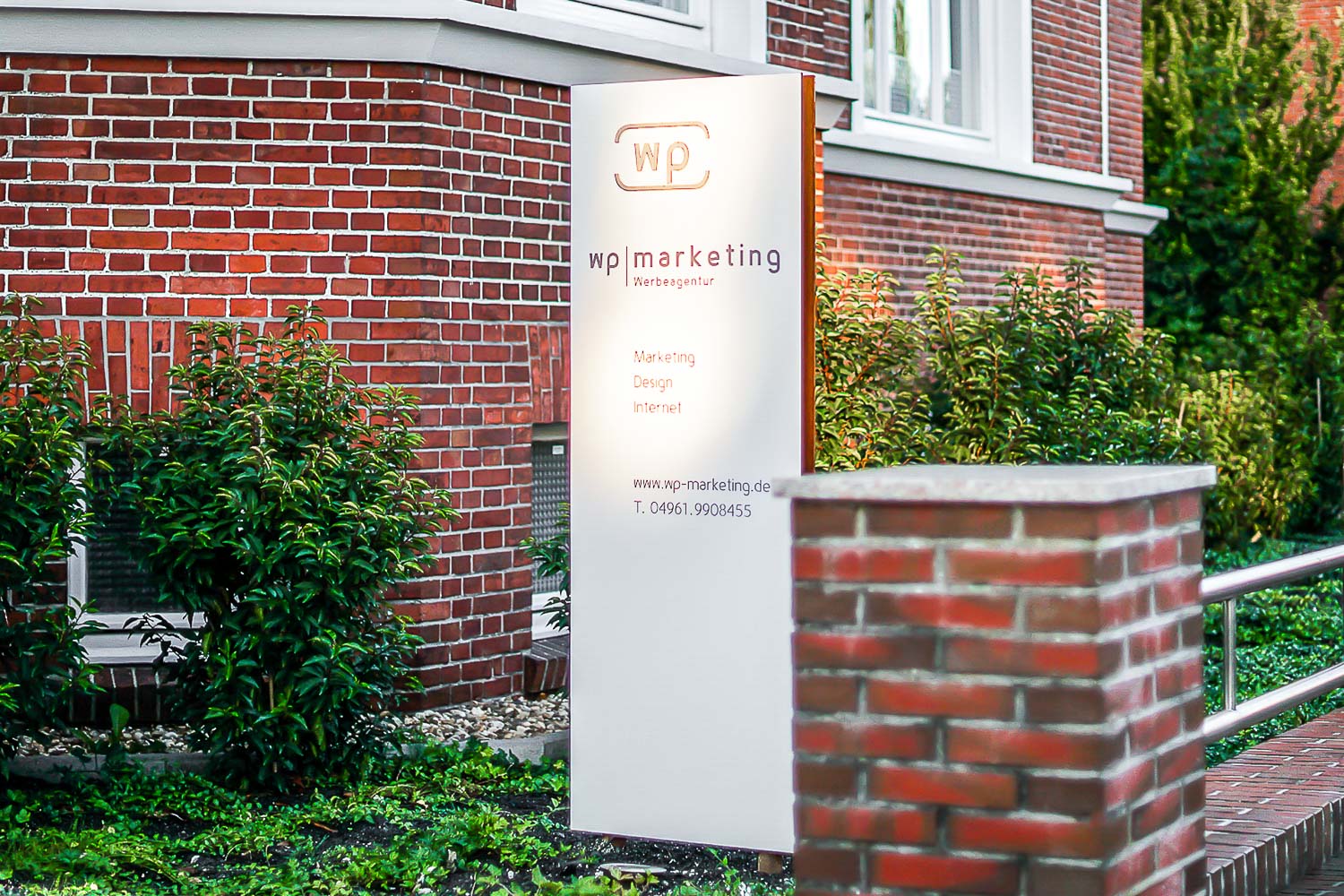 Ein Backsteingebäude mit einem weißen Schild davor
